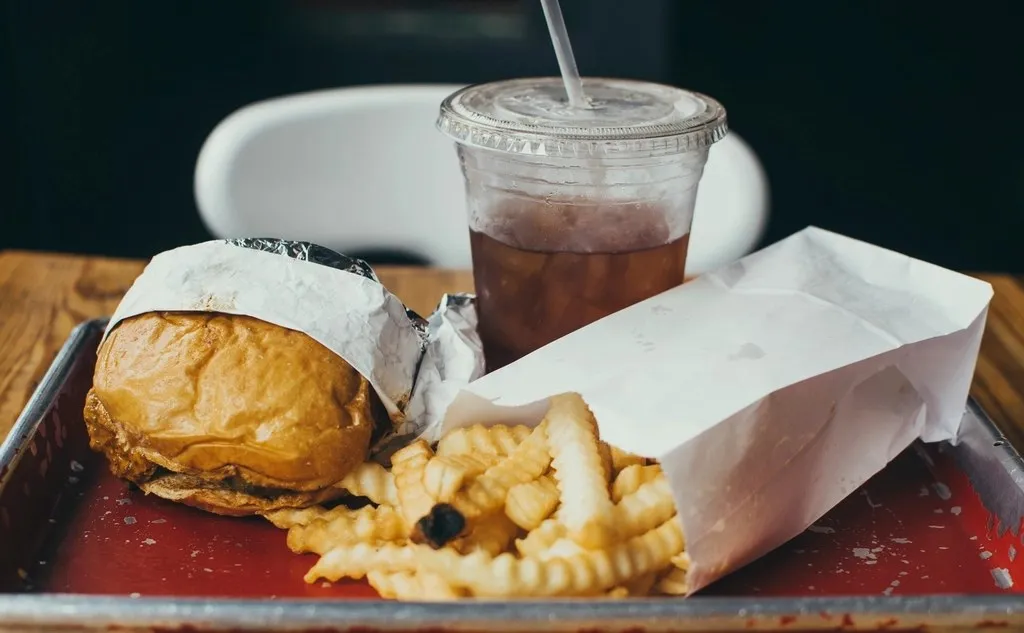 A burger, crinkle-cut fries and an iced drink together on a red tray, the kind of bundle a value offer covers